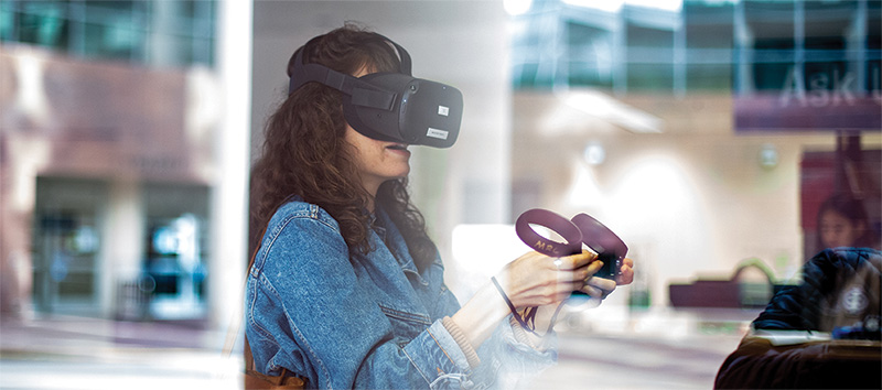 A girl uses Virtual Reality technology from UCI Libraries. 