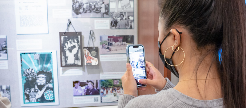 A UCI student visits the UCI Libraries Anteater Spirit exhibit.