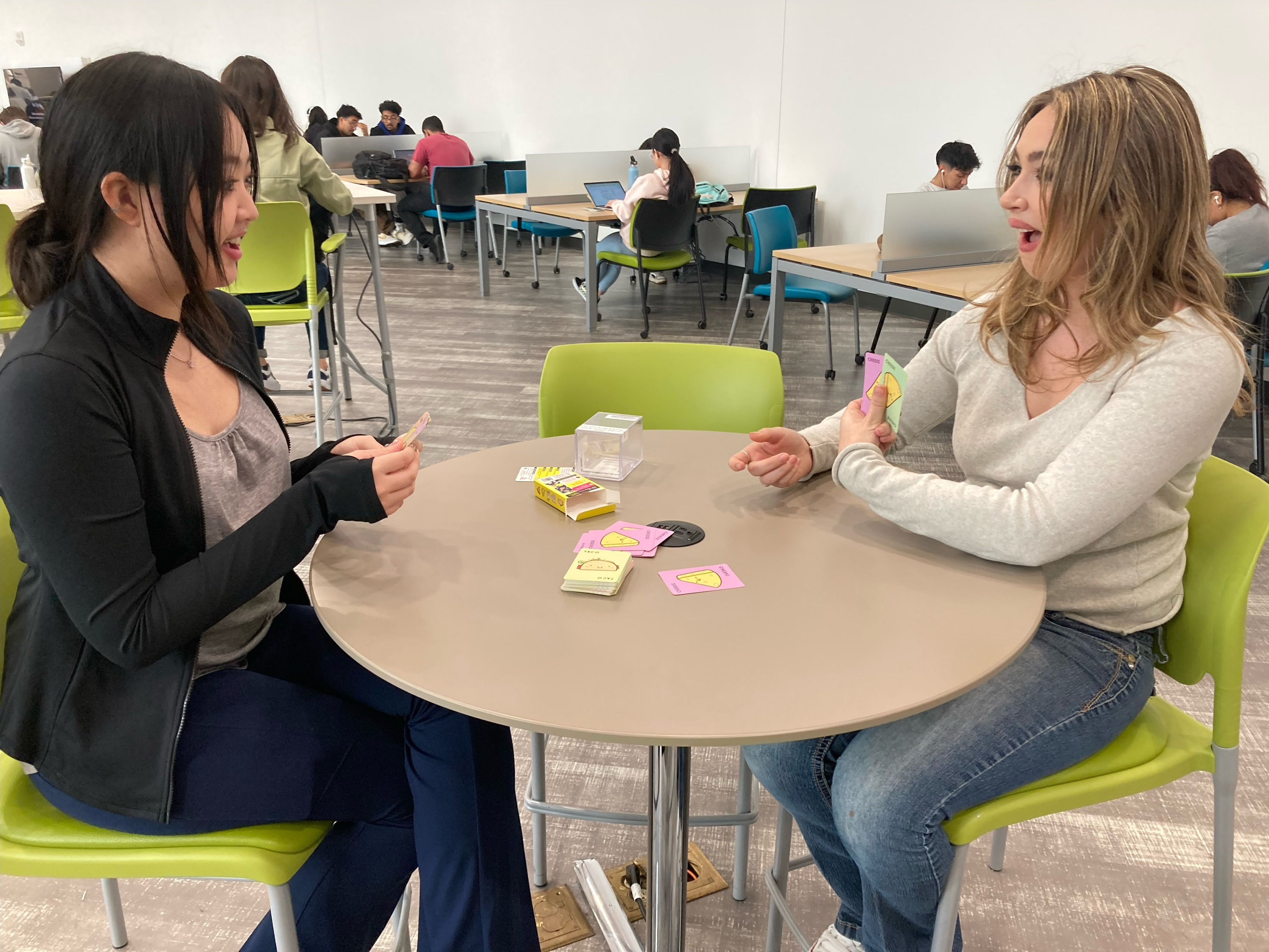 UCI students play a card game together in the Science Library.